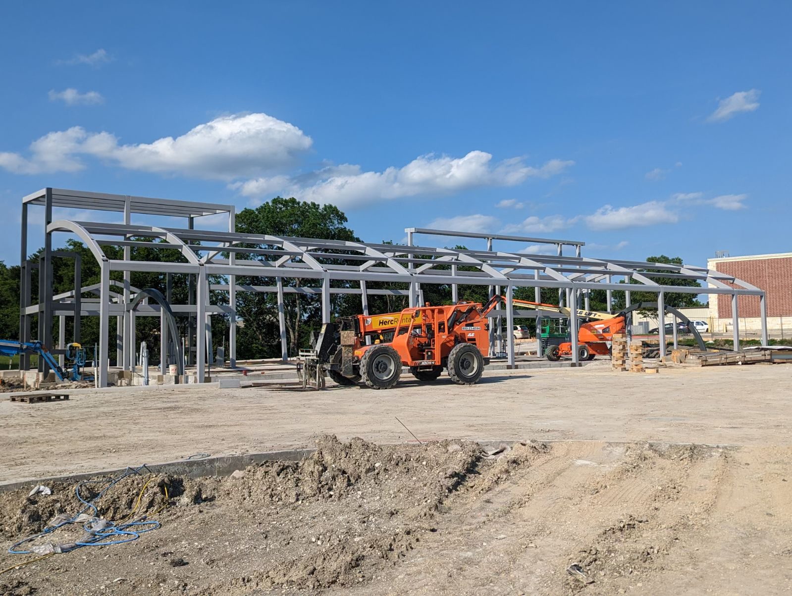 Construction site with tractor and building under construction.