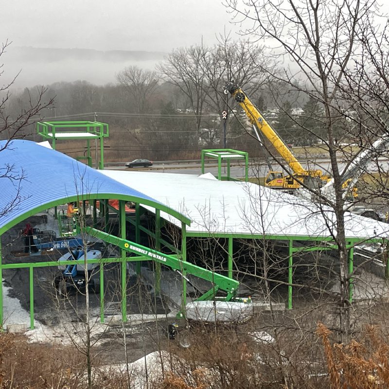 Sustainable architecture: green building with blue roof and crane.