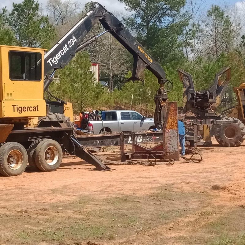 A massive machine parked beside a truck.