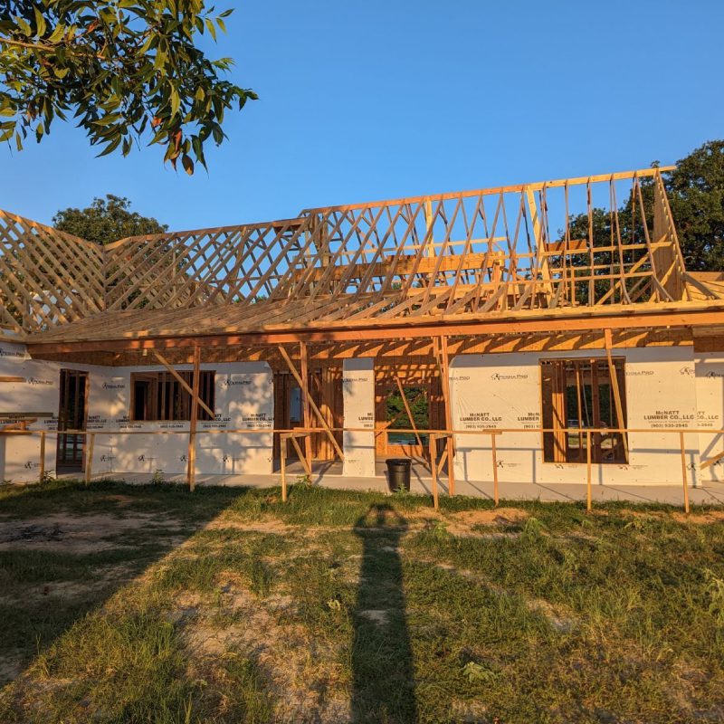 A partially built house with scaffolding and construction materials around it.</p>
<p>